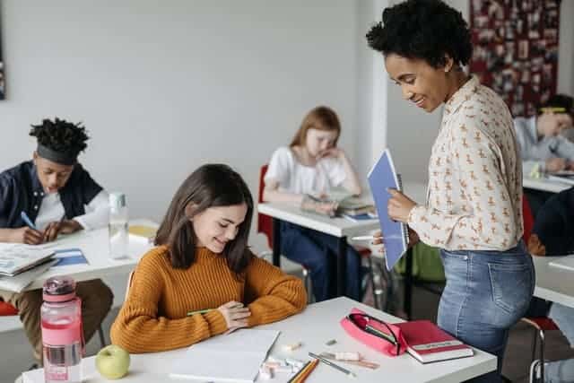 Teacher with student as they journal - teaching respect activities