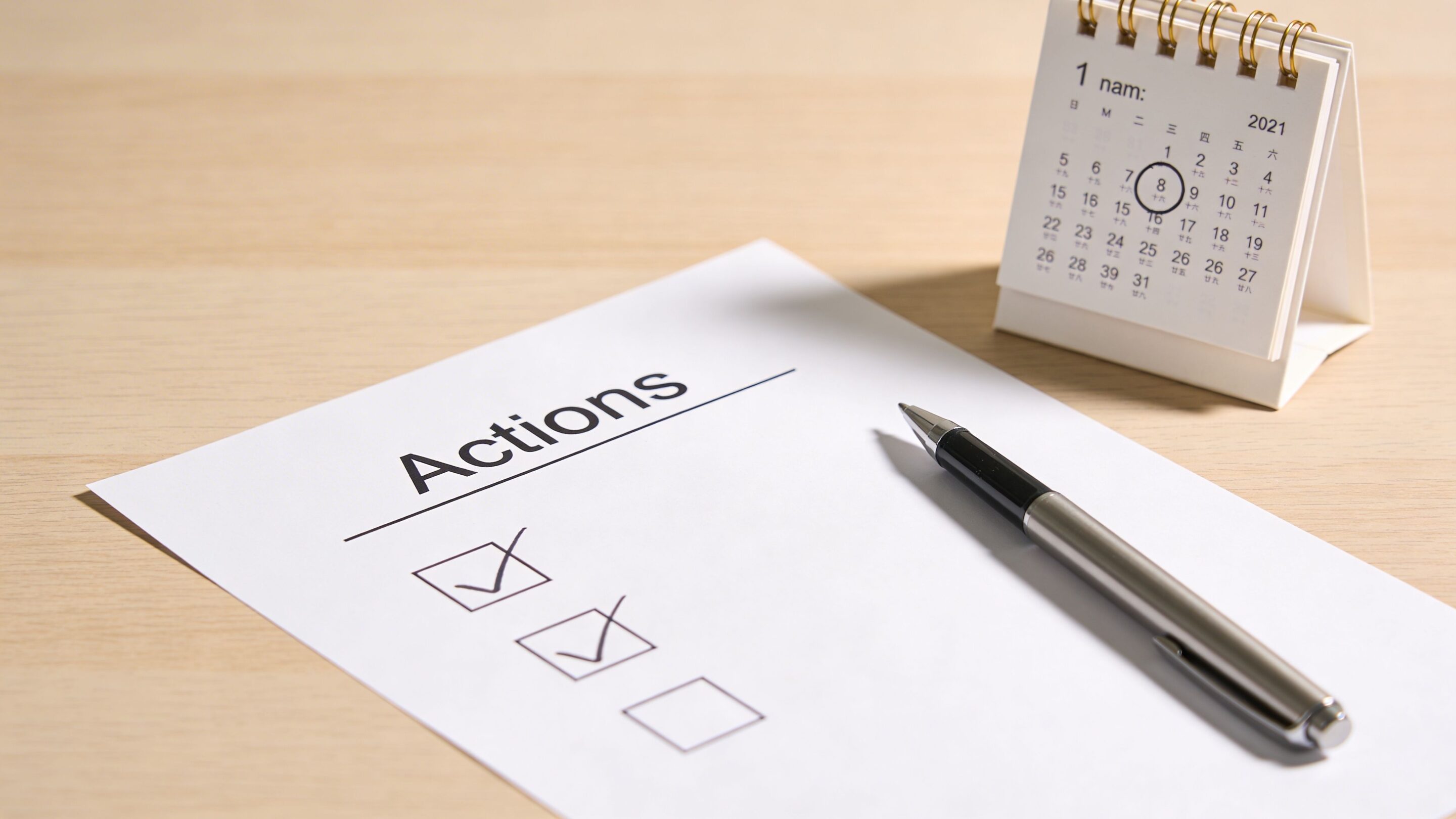 A to-do list titled Actions with checkmarks next to a pen and a desktop calendar.
